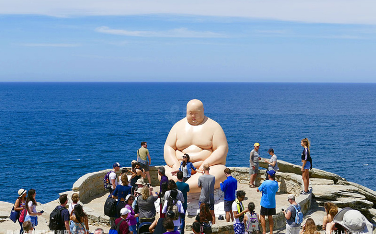 今年、一番人気の海に背を向けて座り込む太った人